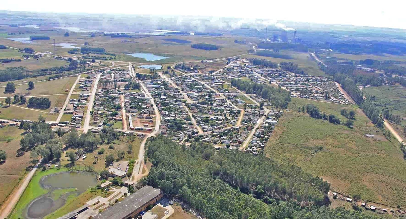 Vista aérea de Candiota: a área urbana cercada pela paisagem do Pampa, com açudes e o complexo termelétrico ao fundo